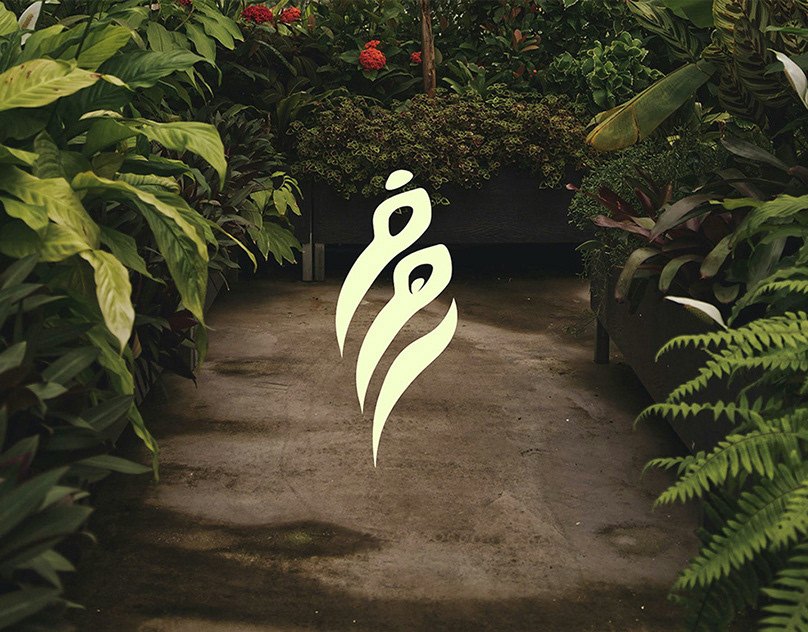 The RAHAF calligraphic mark in pale cream over a greenhouse path lined with ferns